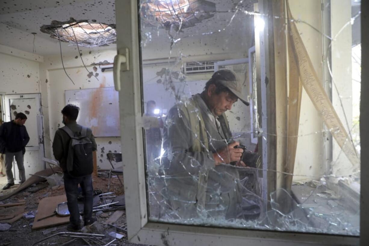 Journalists photograph inside Kabul University after a deadly attack in Kabul, Afghanistan, Tuesday, Nov. 3, 2020. The brazen attack by gunmen who stormed the university has left many dead and wounded in the Afghan capital. The assault sparked an hours-long gun battle.