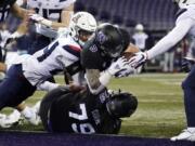 Washington&#039;s Sean McGrew (5) dives over teammate Victor Curne (79) to score against Arizona during the first half of an NCAA college football game Saturday, Nov. 21, 2020, in Seattle.