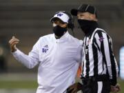 Washington coach Jimmy Lake talks with field judge Todd Migchelbrink during the first half of an NCAA college football game Saturday, Nov. 21, 2020, in Seattle.