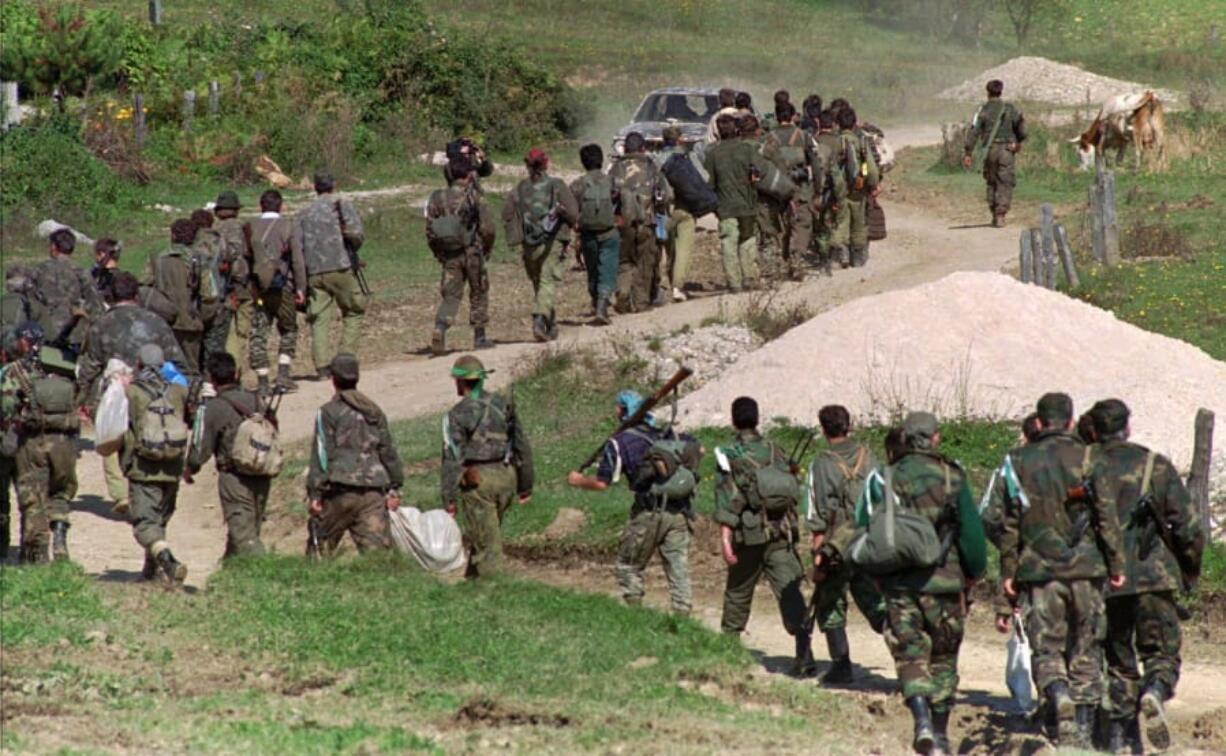 FILE - In this Sept. 28, 1995. file photo, a line of Bosnian government troops makes its way to the front-line near Mrkonjic Grad 120kms (80mls) north west of Sarajevo, Bosnia. While it brought an end to the fighting, the Dayton peace agreement baked in the ethnic divisions, establishing a complicated and fragmented state structure with two semi-autonomous entities, Serb-run Republika Srpska and a Federation shared by Bosniak and Croats, linked by weak joint institutions.