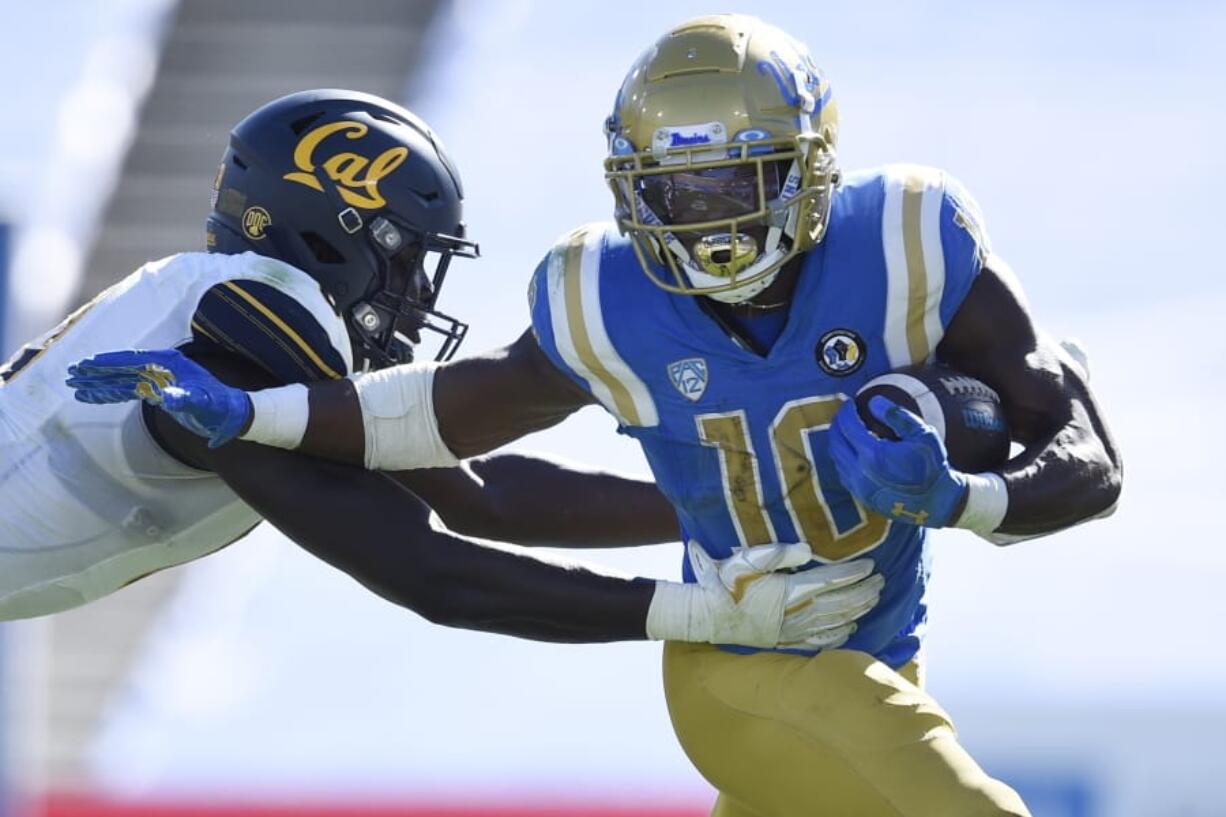 UCLA running back Demetric Felton, right, runs the ball while defended by California linebacker Kuony Deng during the second half of an NCAA college football game in Los Angeles, Sunday, Nov. 15, 2020.