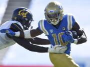 UCLA running back Demetric Felton, right, runs the ball while defended by California linebacker Kuony Deng during the second half of an NCAA college football game in Los Angeles, Sunday, Nov. 15, 2020.