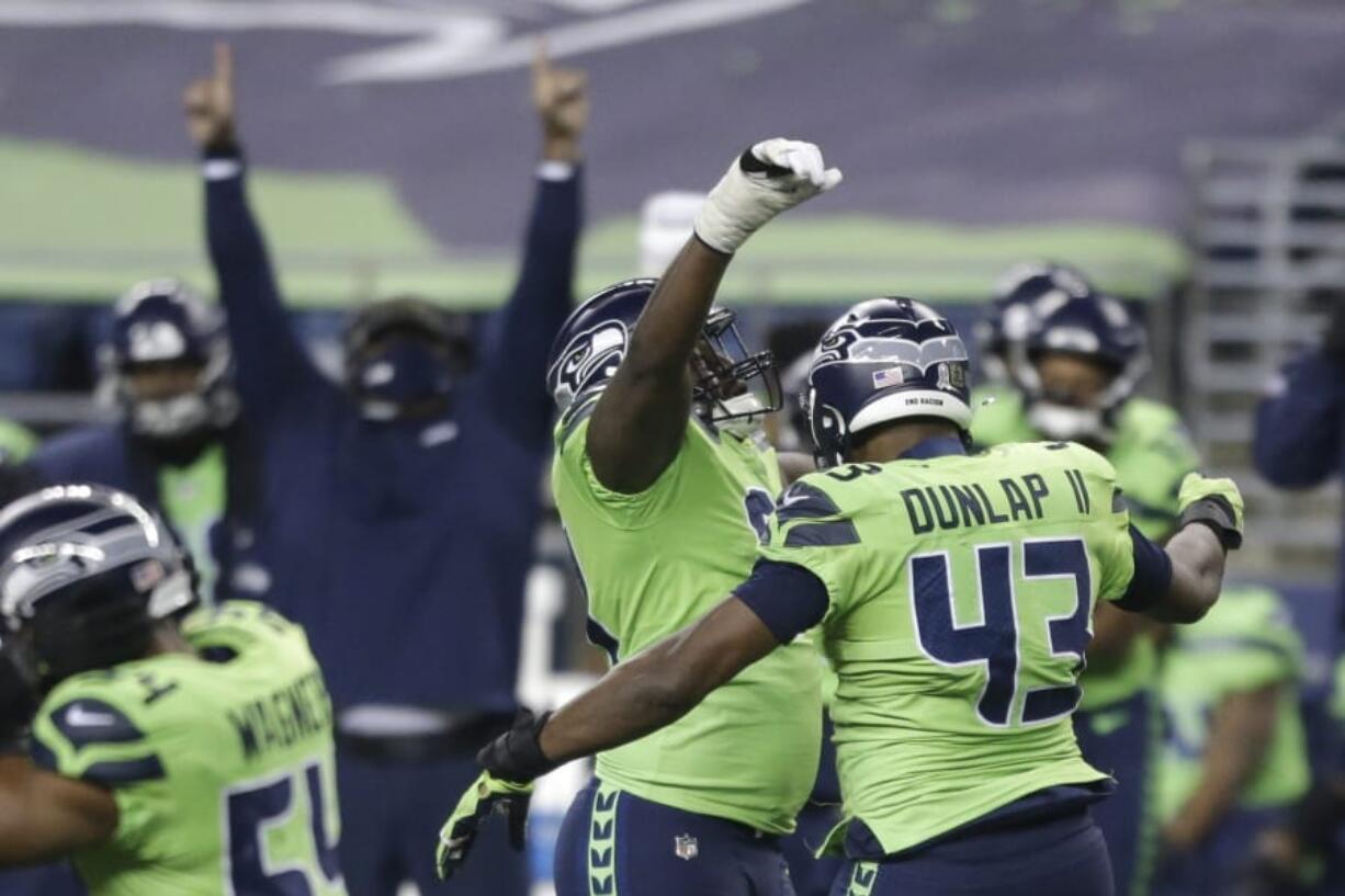 Seattle Seahawks defensive end Carlos Dunlap (43) celebrates with defensive end L.J. Collier, center-left, after Dunlap sacked Arizona Cardinals quarterback Kyler Murray late in the second half of an NFL football game, Thursday, Nov. 19, 2020, in Seattle. The Seahawks won 28-21.