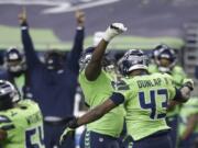 Seattle Seahawks defensive end Carlos Dunlap (43) celebrates with defensive end L.J. Collier, center-left, after Dunlap sacked Arizona Cardinals quarterback Kyler Murray late in the second half of an NFL football game, Thursday, Nov. 19, 2020, in Seattle. The Seahawks won 28-21.