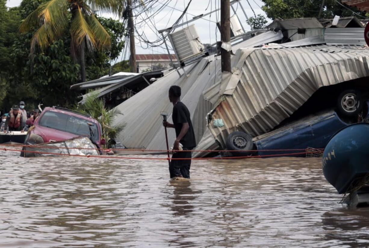 A resident walking through a flooded street Nov. 6 looks back at storm damage caused by Hurricane Eta in Planeta, Honduras.