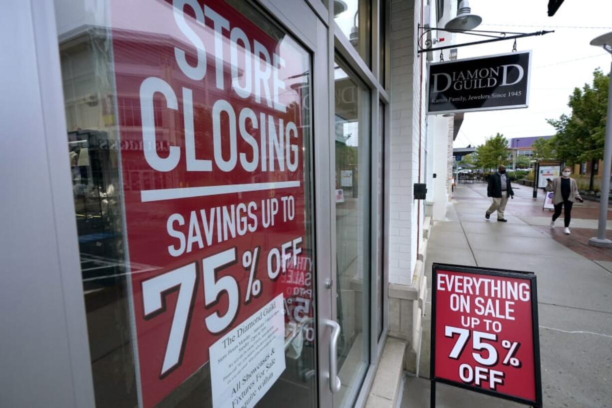 FILE - In this Sept. 2, 2020 file photo, pedestrians walk past a business storefront with store closing and sale signs in Dedham, Mass.  The U.S. economy plunged at a record rate in the spring but is poised to break a record for an increase in the just-ending July-September quarter. The Commerce Department reported Wednesday, Sept. 30, that the gross domestic product, the economy&#039;Aos total output of goods and services, fell at a rate of 31.4% in the April-June quarter, only slightly changed from the 31.7% drop estimated one month ago.