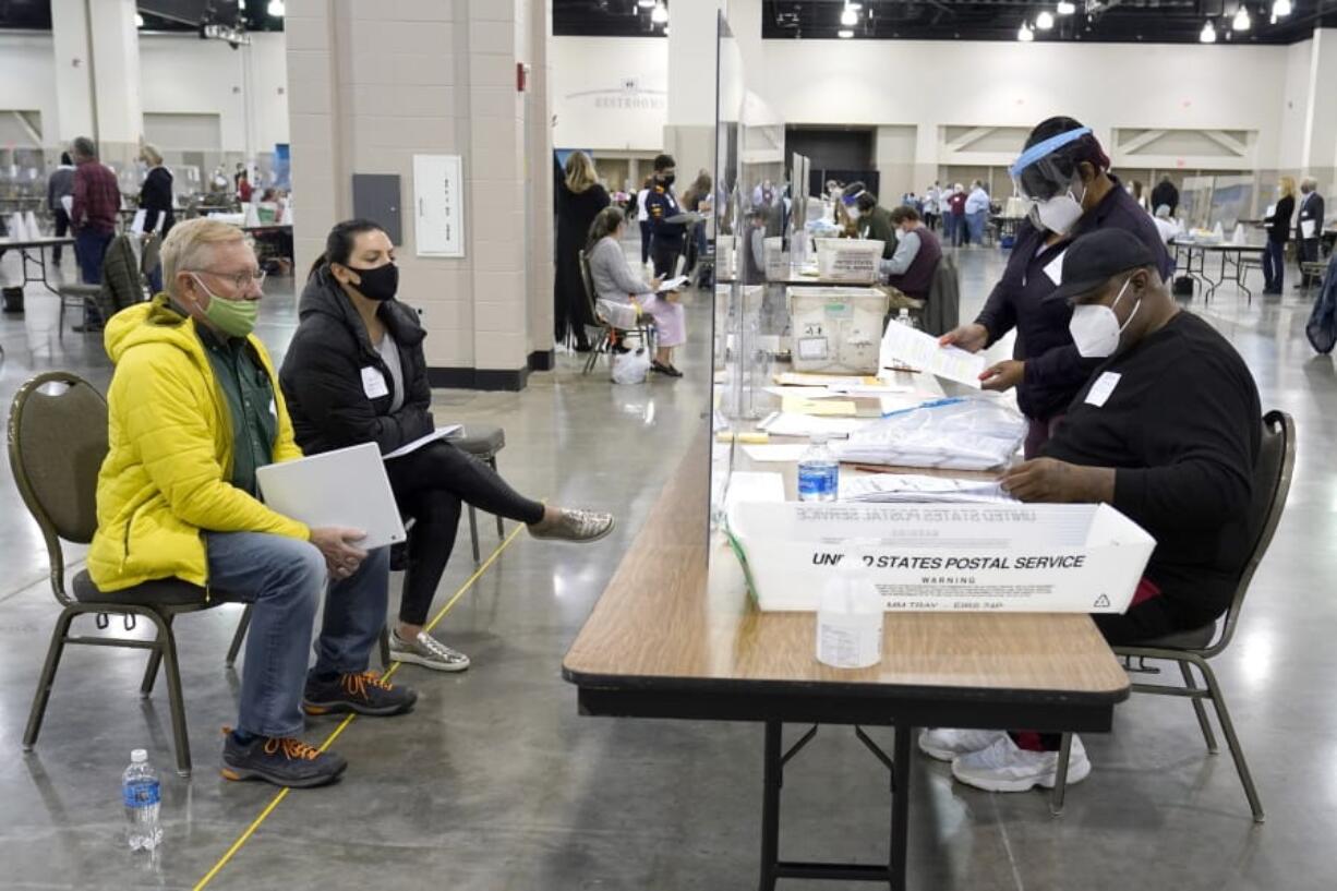 FILE - Election workers, right, verify ballots as recount observers, left, watch during a Milwaukee hand recount of presidential votes at the Wisconsin Center, Friday, Nov. 20, 2020, in Milwaukee. Wisconsin finished a partial recount of its presidential results on Sunday, Nov. 29, 2020 confirming Democrat Joe Biden&#039;s victory over President Donald Trump in the key battleground state. Trump vowed to challenge the outcome in court. (AP Photo/Nam Y.