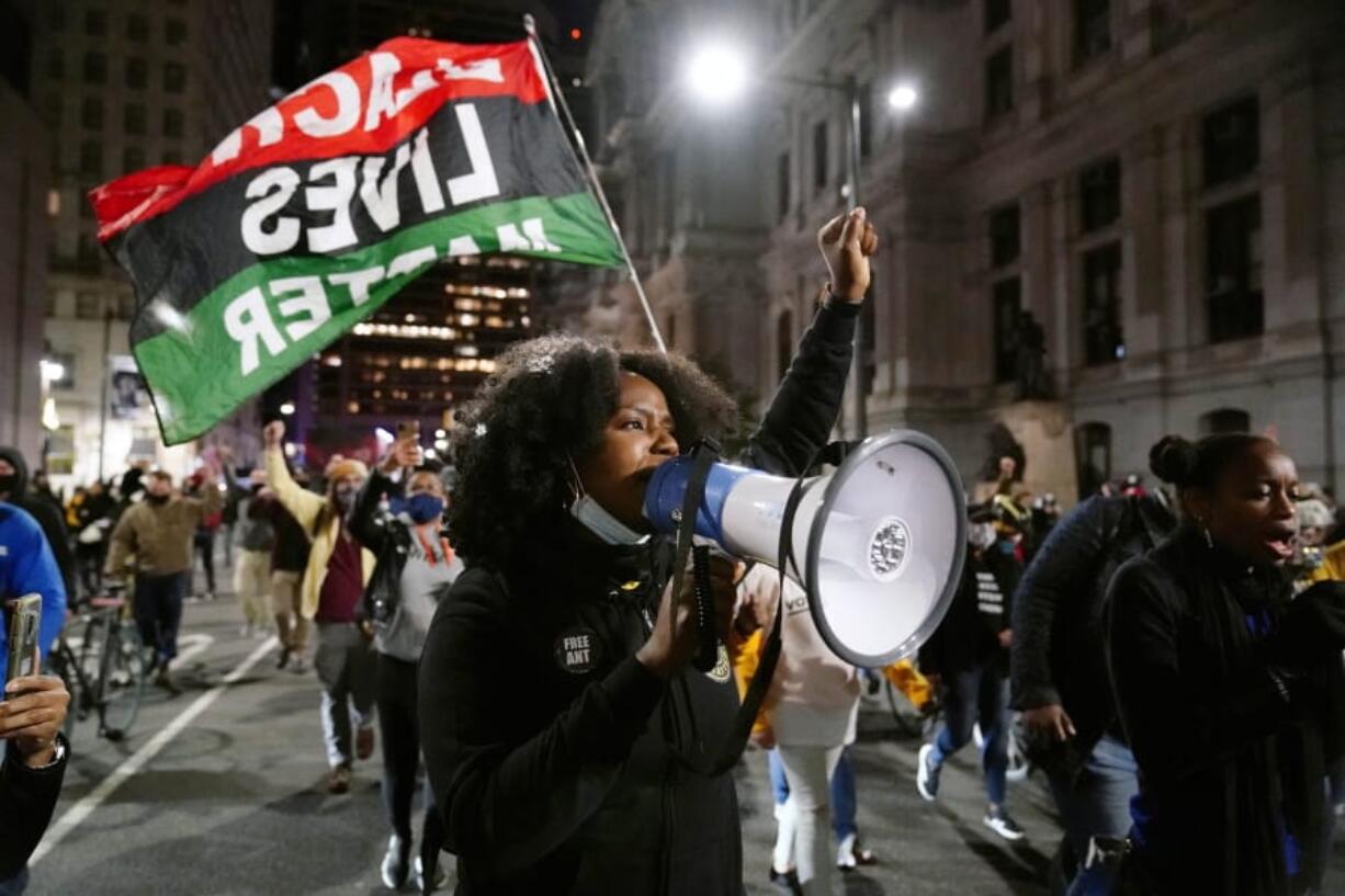 Demonstrators, including one carrying a Black Lives Matter flag, march to urge that all votes be counted, Wednesday, Nov. 4, 2020, in Philadelphia, following Tuesday&#039;s election.