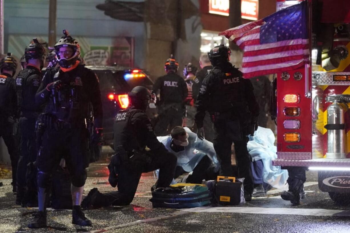 Emergency crews attend an injured man detained by police during a protest after the Nov. 3 elections in front of the east precinct station, Wednesday, Nov. 4, 2020, in Seattle. (AP Photo/Ted S.