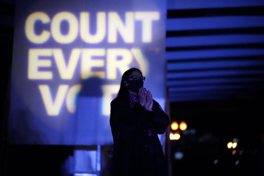 A woman listens during a protest after the Nov. 3 elections, Wednesday, Nov. 4, 2020, in Portland, Ore.