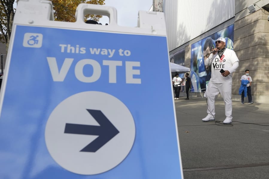 Paul Patu performs hip-hop music with the theme of &quot;Drop The Vote,&quot; Monday, Nov. 2, 2020, outside a voting center in Seattle where people can drop off ballots or get help registering to vote or obtaining their ballots. Patu is the executive director of the Seattle-based organization Urban Family, who came up with the Drop The Vote campaign to encourage and educate voters from underserved communities. (AP Photo/Ted S.