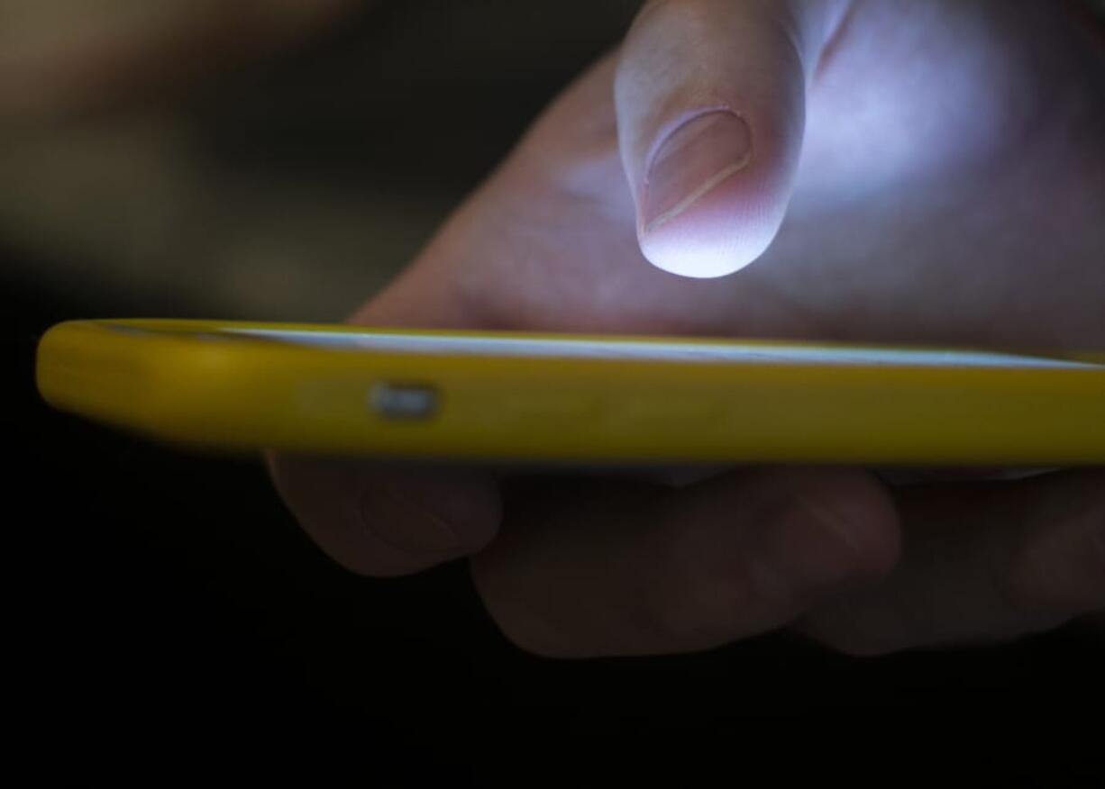 FILE - In this Aug. 11, 2019, file photo, a man uses a cell phone in New Orleans. Voters across the U.S. received anonymous robocalls in the days and weeks before Election Day urging them to &quot;stay safe and stay home&quot; -- an ominous warning that election experts said could be an effort to scare voters into sitting out the election.