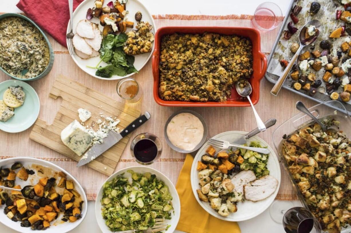 This October 2017 photo taken in New York, shows a Thanksgiving spread with hot spinach and mushroom dip, turkey, cornbread stuffing and sauteed brussel sprouts. A meal like this can be cooked and readied to be enjoyed in multiple homes and connected via Zoom, or virtually, during this year&#039;s Thanksgiving holiday.