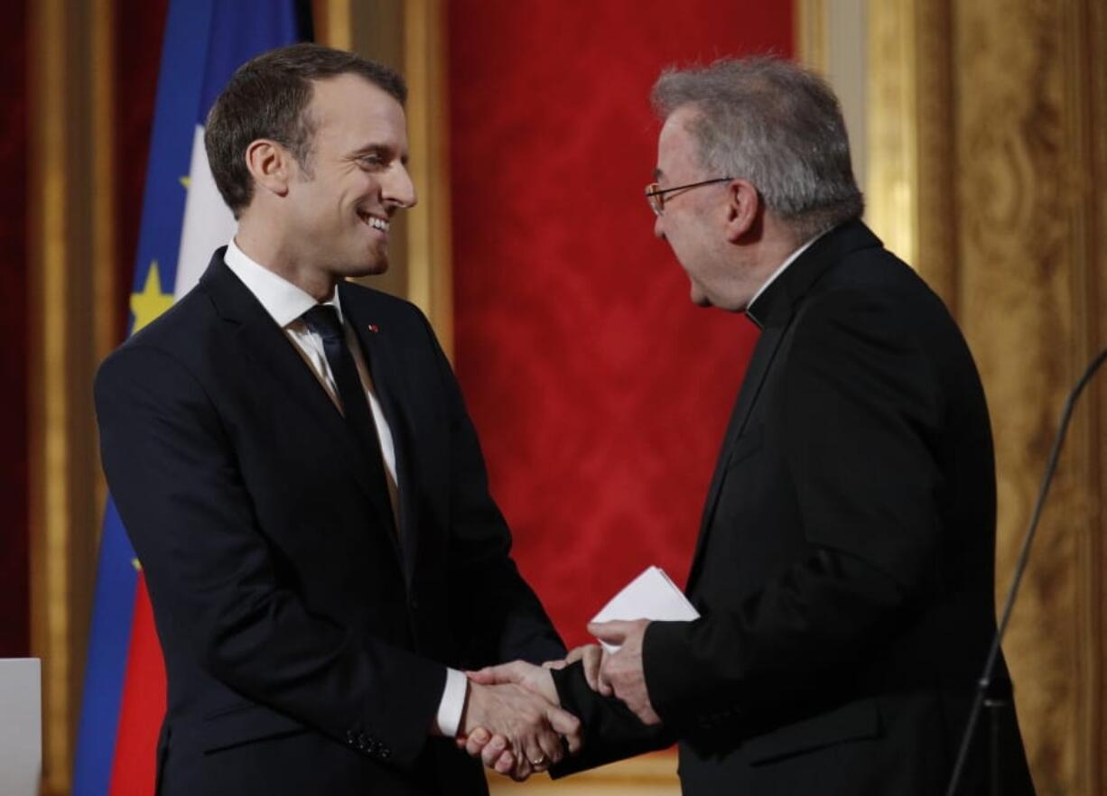 FILE - In this Jan.4, 2018 file photo, French President Emmanuel Macron, left, greets Apostolic Nuncio to France Luigi Ventura, at the Elysee Palace in Paris. Multiple men have accused Archbishop Luigi Ventura of groping and inappropriate touching, and the Vatican&#039;s former ambassador to France goes on trial Tuesday Nov. 10, 2020, for alleged sexual misconduct.