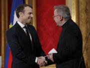 FILE - In this Jan.4, 2018 file photo, French President Emmanuel Macron, left, greets Apostolic Nuncio to France Luigi Ventura, at the Elysee Palace in Paris. Multiple men have accused Archbishop Luigi Ventura of groping and inappropriate touching, and the Vatican&#039;s former ambassador to France goes on trial Tuesday Nov. 10, 2020, for alleged sexual misconduct.