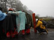 Volunteer firefighters huddle in prayer before beginning a search and rescue operation in San Cristobal Verapaz, Saturday, Nov. 7, 2020, in the aftermath of Hurricane Eta. Searchers in Guatemala were digging through mud and debris looking for an estimated 100 people believed buried by a massive, rain-fueled landslide, as Eta regained tropical storm strength and churned toward Cuba.