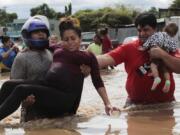 A pregnant woman is carried out of an area flooded by water brought by Hurricane Eta in Planeta, Honduras, Thursday, Nov. 5, 2020. The storm that hit Nicaragua as a Category 4 hurricane on Tuesday had become more of a vast tropical rainstorm, but it was advancing so slowly and dumping so much rain that much of Central America remained on high alert.