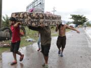 Neighbors help each other as they evacuate the area before Hurricane Iota makes landfall in San Manuel Cortes, Honduras, Monday, November 16, 2020. Hurricane Iota rapidly strengthened into a Category 5 storm that is likely to bring catastrophic damage to the same part of Central America already battered by a powerful Hurricane Eta less than two weeks ago.