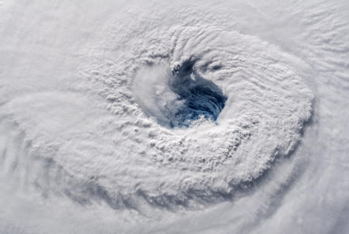 FILE - In this Sept. 12, 2018 photo provided by NASA, Hurricane Florence churns over the Atlantic Ocean heading for the U.S. east coast as seen from the International Space Station. Astronaut Alexander Gerst, who shot the photo, tweeted: &quot;Ever stared down the gaping eye of a category 4 hurricane?