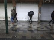 People walk in front of closed shops at Tehran&#039;s Grand Bazaar, Iran&#039;s main business and trade hub, Satuday, Nov. 21, 2020. Iran on Saturday shuttered businesses and curtailed travel between its major cities, including the capital of Tehran, as it grapples with the worst outbreak of the coronavirus in the Mideast region.