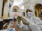 A medical operator prepares to perform COVID-19 test swabs in the Church of San Severo Outside the Walls, in the heart of Naples, Italy, Wednesday, Nov. 18, 2020. An initiative of &quot;Sanita&#039; Diritti Salute&quot; association and the San Gennaro Foundation, aimed at helping those who cannot afford the cost of a private test, also allows, in the best tradition of Naples, those who want to pay 18 euros for a &quot;suspended swab&quot;, to be taken by somebody else, exactly as it happens for the famous Neapolitan &quot;suspended coffee&quot;.