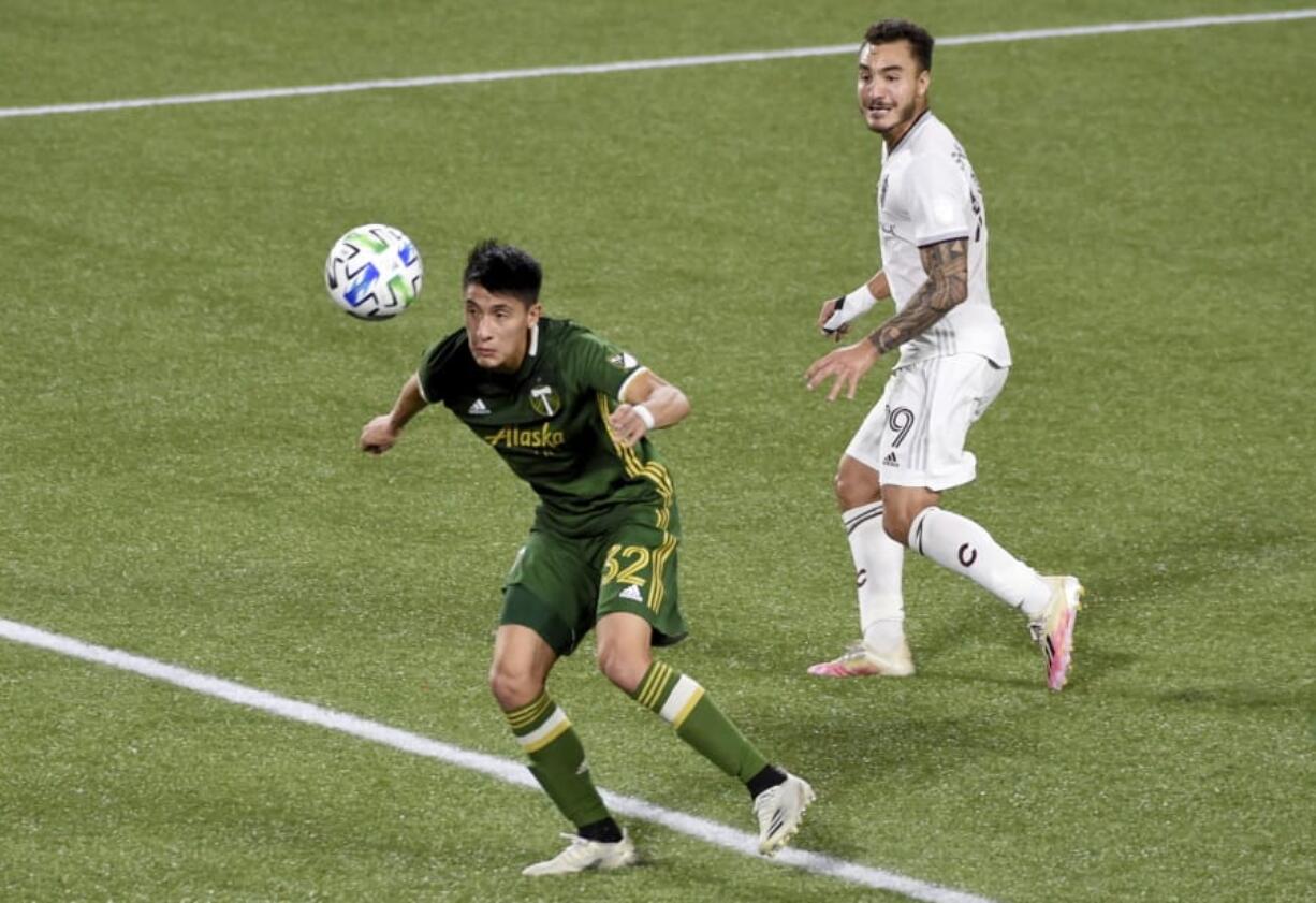 Portland Timbers defender Marco Farfan, left, heads the ball away from in front of the goal as Colorado Rapids forward Andre Shinyashiki looks on during the first half of an MLS soccer match in Portland, Ore., Wednesday, Nov. 4, 2020.