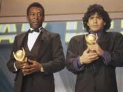 FILE - In this March 1987 file photo, Pele, left, and Maradona hold &quot;Sports Oscar&quot; trophies in Milan, Rome. The Argentine soccer great who was among the best players ever and who led his country to the 1986 World Cup title before later struggling with cocaine use and obesity, died from a heart attack on Wednesday, Nov. 25, 2020, at his home in Buenos Aires. He was 60.