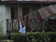 A woman works to recover the part of roof damaged by Hurricane Eta in Wawa, Nicaragua, Tuesday, Nov. 3, 2020. Eta slammed into Nicaragua&#039;s Caribbean coast with potentially devastating winds Tuesday, while heavy rains thrown off by the Category 4 storm already were causing rivers to overflow across Central America.