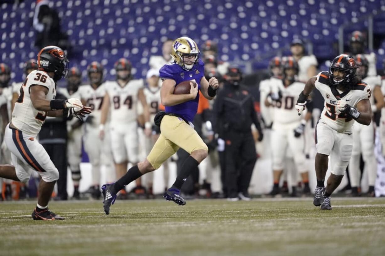 Washington quarterback Dylan Morris keeps the ball as Oregon State&#039;s Omar Speights, left, and Avery Roberts, right, close in during the second half of an NCAA college football game, Saturday, Nov. 14, 2020, in Seattle. Washington won 27-21. (AP Photo/Ted S. Warren) (Ted S.