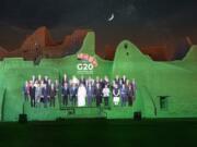 In this handout image provided by DGDA, Diriyah Gate Development Authority of Saudi, a family photo featuring members of the G20 is projected onto the walls of Salwa Palace, At Turaif on Saturday, Nov. 20, 2020 in Diriyah, on the outskirts of Riyadh, Saudi Arabia.