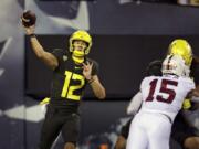 Oregon&#039;s Tyler Shough, left, throws downfield against Stanford during the second quarter of an NCAA college football game Saturday, Nov. 7, 2020, in Eugene, Ore.