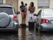 Evan and Denise Knight try to keep dry along with their baby Zion, on a flooded street in Melrose Park in Fort Lauderdale, Fla., Monday, Nov. 9, 2020. Heavy rain from Tropical Storm Eta caused dangerous flooding Monday across Florida&#039;s most densely populated urban areas, stranding cars and swamping entire neighborhoods with fast-rising water that had no place to drain.