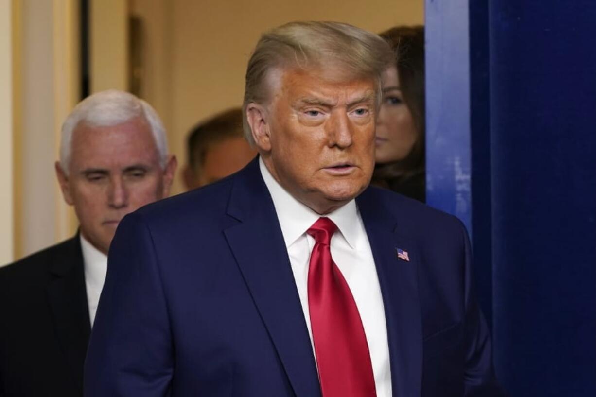 President Donald Trump, followed by Vice President Mike Pence, left, walks into the briefing room at the White House in Washington, Tuesday, Nov. 24, 2020, to make a statement.