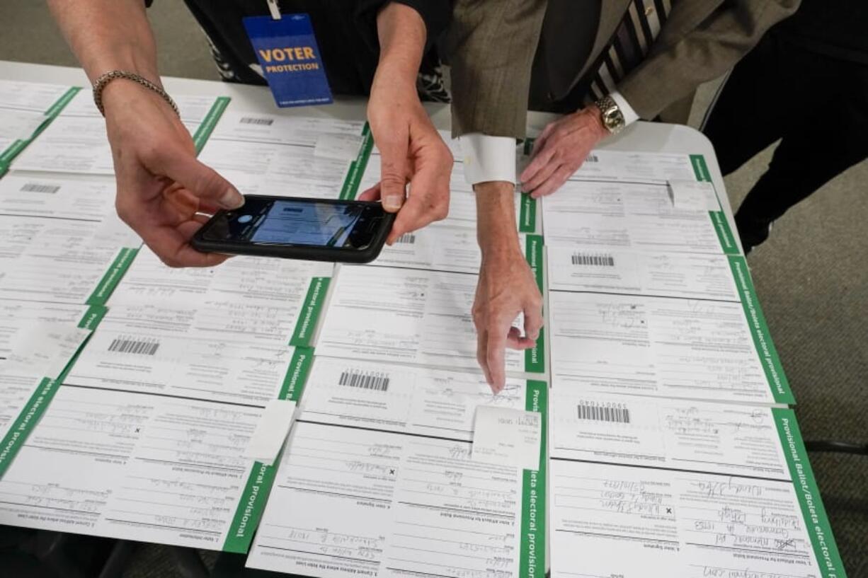 FILE - In this Nov. 6, 2020, photo, a canvas observer photographs Lehigh County provisional ballots as vote counting in the general election continues in Allentown, Pa. President Donald Trump&#039;s campaign filed a number of lawsuits across six battleground states this month as he tried to upend the 2020 election. Judges uniformly rejected his claims of vote fraud. The latest case ended Saturday, Nov.