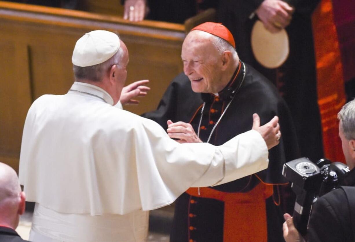 FILE - In this Sept. 23, 2015 file photo, Pope Francis reaches out to hug Cardinal Archbishop emeritus Theodore McCarrick after the Midday Prayer of the Divine with more than 300 U.S. bishops, at the Cathedral of St. Matthew the Apostle in Washington. On Tuesday, Nov. 10, 2020, the Vatican is taking the extraordinary step of publishing its two-year investigation into the disgraced ex-Cardinal McCarrick, who was defrocked in 2019 after the Vatican determined that years of rumors that he was a sexual predator were true.