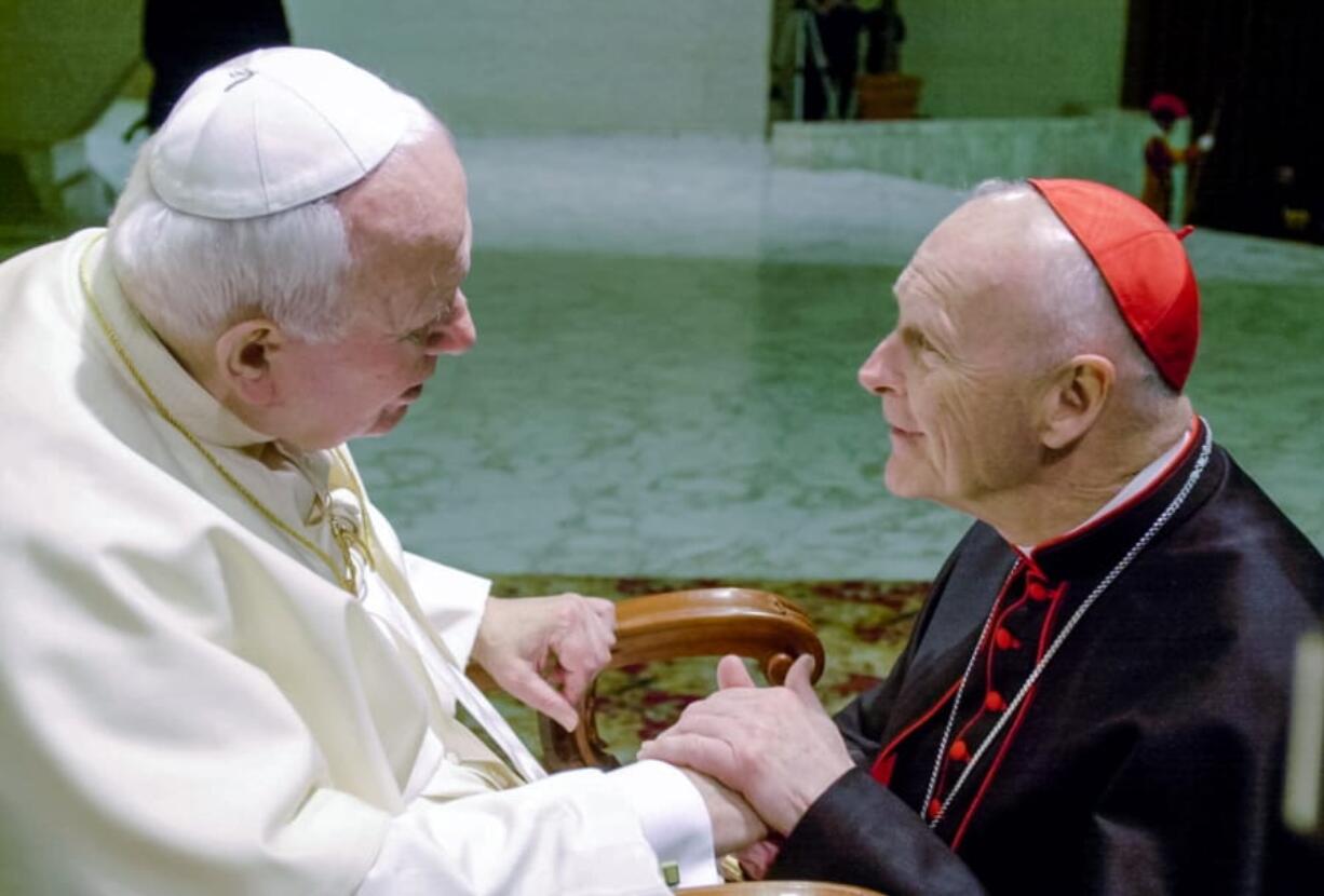 FILE - In this Feb. 23, 2001 file photo, U.S. Cardinal Theodore Edgar McCarrick, archbishop of Washington, D.C., shakes hands with Pope John Paul II during the General Audience with the newly appointed cardinals in the Paul VI hall at the Vatican. McCarrick was one of the three Americans on a record list of 44 new cardinals who were elevated in a ceremony at the Vatican on Feb. 21, 2001.