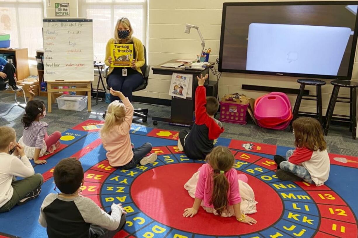 In this photo provided by Julie Mackett, the kindergarten teacher conducts her class at Ft. Meigs Elementary School, in Perrysburg, Ohio. Contact tracing and isolation protocols meant to contain the spread of the coronavirus are sidelining school employees and frustrating efforts to continue in-person learning. &quot;I think everybody understands when you can&#039;t have enough subs to fill the roles, it&#039;s also a safety issue: You can&#039;t have that many children without support from adults,&quot; said Mackett, who went through her own two-week quarantine early in the school year after a student tested positive.