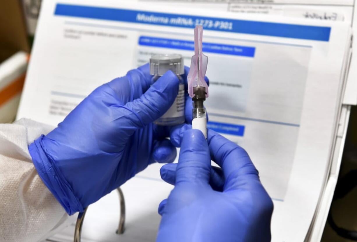 FILE - In this July 27, 2020, file photo, nurse Kathe Olmstead prepares a shot that is part of a possible COVID-19 vaccine, developed by the National Institutes of Health and Moderna Inc., in Binghamton, N.Y. Moderna Inc. says it will ask U.S. and European regulators to allow emergency use of its COVID-19 vaccine as new study results confirm the shots offer strong protection.