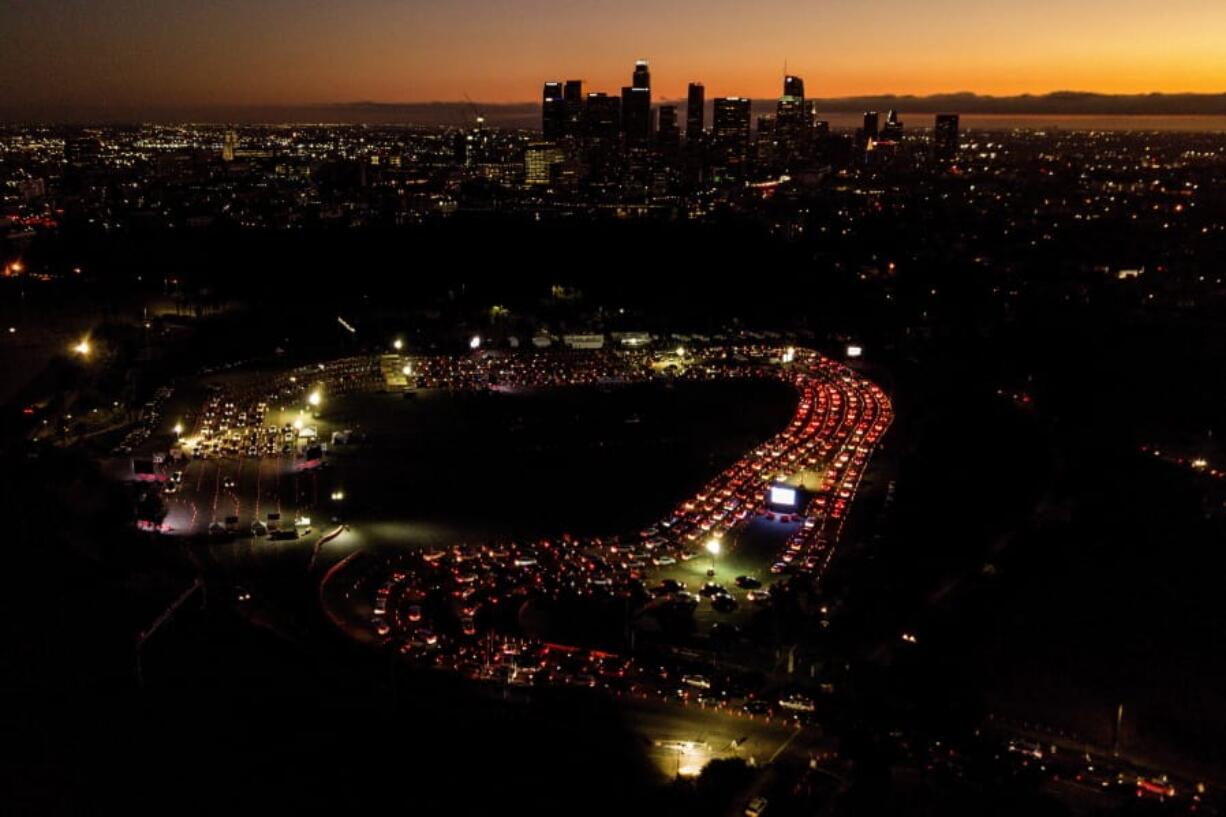 FILE - In this Nov 18, 2020, file photo, motorists wait in long lines to take a coronavirus test in a parking lot at Dodger Stadium in Los Angeles. With coronavirus cases surging and families hoping to gather safely for Thanksgiving, long lines to get tested have reappeared across the U.S. (AP Photo/Ringo H.W.