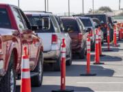 FILE - In this Oct. 14, 2020, file photo, vehicles are lined up for drive-thru COVID-19 testing in El Paso, Texas. As the coronavirus pandemic surges across the nation and infections and hospitalizations rise, medical administrators are scrambling to find enough nursing help -- especially in rural areas and at small hospitals. (Aaron E.