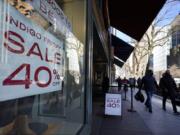 Shoppers pass an Indigo Friday 40% Off sign Saturday, Nov. 28, 2020, on Chicago&#039;s famed Magnificent Mile shopping district.