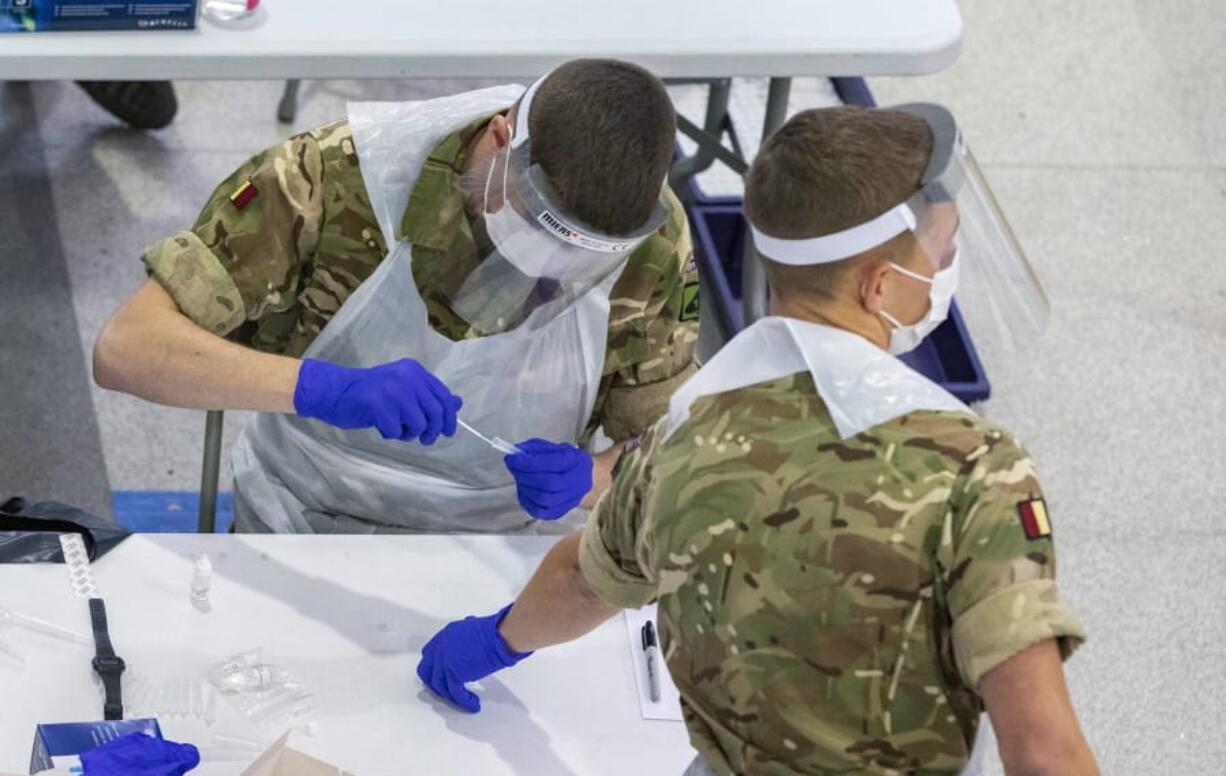 Soldiers carry out mass coronavirus testing, set up at a marketplace in Liverpool, England, during the four-week national lockdown to curb the spread of coronavirus in England, Wednesday Nov. 11, 2020.