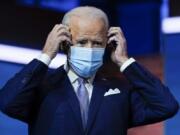 FILE - In this Nov. 24, 2020, file photo President-elect Joe Biden puts on his face mask after introducing nominees and appointees to key national security and foreign policy posts at The Queen theater in Wilmington, Del.