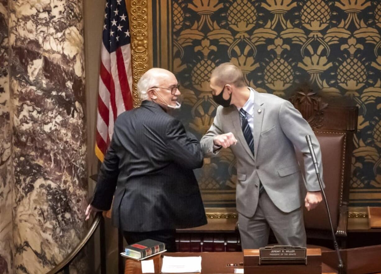 FILE - In this Nov. 12, 2020 file photo, outgoing Senate President Senate President Jeremy Miller, R-Winona gave Sen. David Tomassoni, DFL-Chisholm a congratulatory elbow bump before Tomassoni addressed the Senate Chamber. At least 187 state legislators nationwide have tested positive for the virus and four have died since the pandemic began, according to figures compiled by The Associated Press. Twelve Arkansas lawmakers have tested positive for the virus over the past month, the second largest known outbreak in a state legislature.