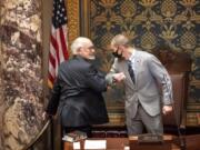 FILE - In this Nov. 12, 2020 file photo, outgoing Senate President Senate President Jeremy Miller, R-Winona gave Sen. David Tomassoni, DFL-Chisholm a congratulatory elbow bump before Tomassoni addressed the Senate Chamber. At least 187 state legislators nationwide have tested positive for the virus and four have died since the pandemic began, according to figures compiled by The Associated Press. Twelve Arkansas lawmakers have tested positive for the virus over the past month, the second largest known outbreak in a state legislature.