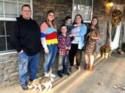 Keith Michael, left, poses with his children, from left, Jessica, Hunter, Houston, Sara and Holly, outside their home on Friday, Nov. 13, 2020, in Jonesboro, Ark. Among the victims of the coronavirus is Michael&#039;s wife, fourth-grade Arkansas teacher Susanne Michael, who died less than three months after celebrating the adoption of three of the children.