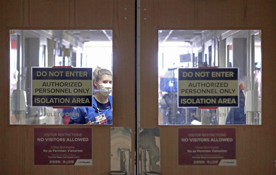 FILE - In this Nov. 5, 2020, file photo, doors to a COVID-19 treatment unit at UW Health in Madison, Wis., caution hospital personnel and visitors. Conditions inside the nation&#039;s hospitals are deteriorating by the day as the coronavirus rages through the country at an unrelenting pace.