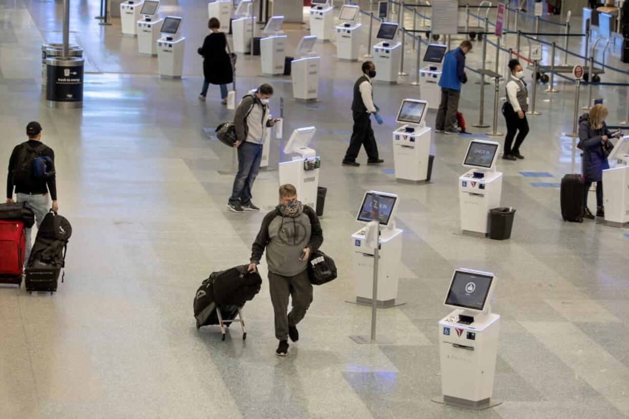 FILE - In this Nov. 12, 2020, file photo, travelers make their way through the Minneapolis-St. Paul International Airport during the coronavirus pandemic. With the coronavirus surging out of control, the nation&#039;s top public health agency advised Americans on Thursday, Nov.