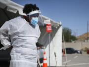 FILE - In this Oct. 26,2020, file photo, a medical worker stands at a COVID-19 state drive-thru testing site at UTEP, in El Paso, Texas. The U.S. has recorded about 10.3 million confirmed infections, with new cases soaring to all-time highs of well over 120,000 per day over the past week.