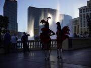 People walk along the Las Vegas Strip, Thursday, Nov. 19, 2020, in Las Vegas. As the coronavirus surges to record levels in Nevada, the governor has implored residents to stay home. But Democrat Steve Sisolak has also encouraged out-of-state visitors, the lifeblood of Nevada&#039;s limping economy, to come to his state and spend money in Las Vegas.